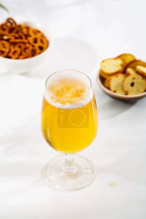 Foto de Un vaso de cerveza ligera y aperitivos en un tazón de comida y bebida - Imagen libre de derechos