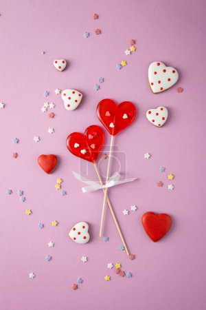 Photo for Two lollipops in shape of heart Valentine s Day concept on pink surface - Royalty Free Image