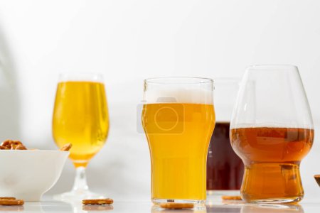 Téléchargez les photos : Plusieurs verre serti de bière claire sombre sur fond clair - en image libre de droit