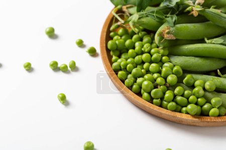 Photo for Green peas pods and seeds on wooden plate - Royalty Free Image