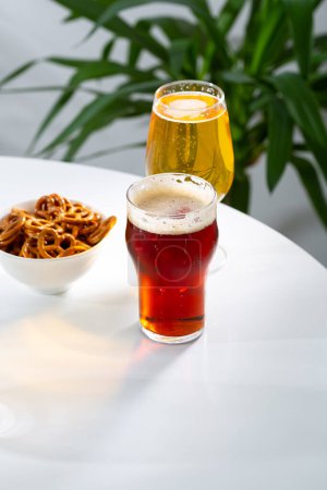 Foto de Dos vasos con aperitivo de cerveza fría y bebida en la mesa ligera - Imagen libre de derechos