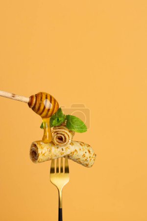 Foto de Primer plano de crepes panqueque con miel en el fondo de la comida tenedor - Imagen libre de derechos