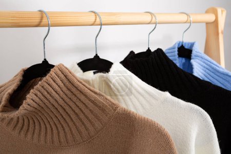 Téléchargez les photos : Quatre pulls tricotés chauds sur un cintre - en image libre de droit