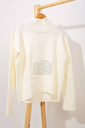Foto de Jersey de lana blanca colgando de una percha - Imagen libre de derechos
