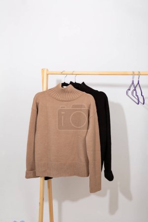 Photo for Beige and black wool sweater hanging on a hanger - Royalty Free Image