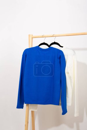 Foto de Jersey de lana y algodón colgado en una percha de madera ropa acogedora - Imagen libre de derechos