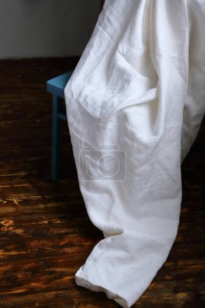 Téléchargez les photos : Linge de lit blanc naturel textile sur chaise dans la chambre plancher en bois - en image libre de droit