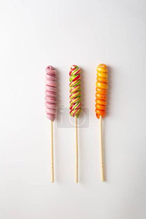 Téléchargez les photos : Sucette sucrée pop bonbons tourbillonnants sur la surface blanche - en image libre de droit