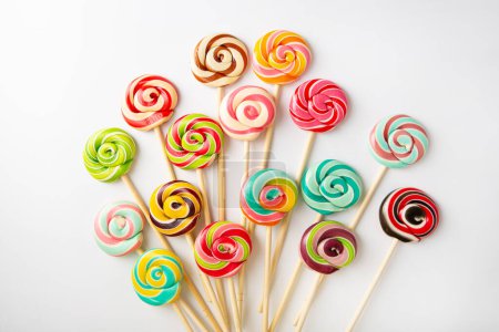 Photo for Sweet lolli pop swirly candies confection on white surface food background - Royalty Free Image