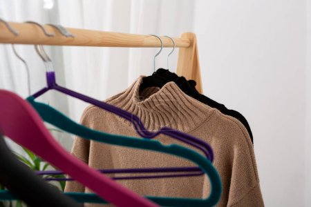Téléchargez les photos : Pulls tricotés chauds et cintres vides - en image libre de droit