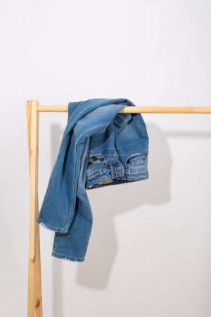 Photo for Blue jeans denim pants on a wooden rack - Royalty Free Image