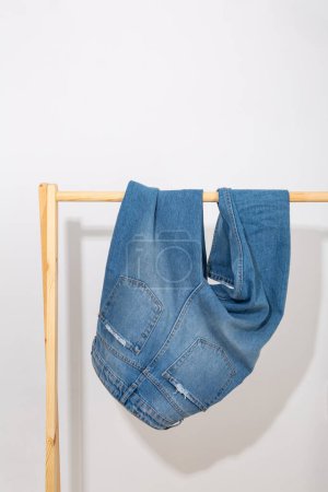 Photo for Blue denim pants on a wooden rack - Royalty Free Image