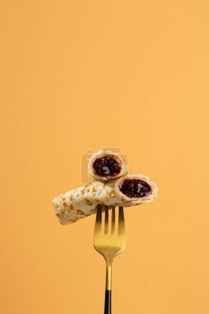 Foto de Crepes rellenos con mermelada de cereza en la comida de tenedor - Imagen libre de derechos