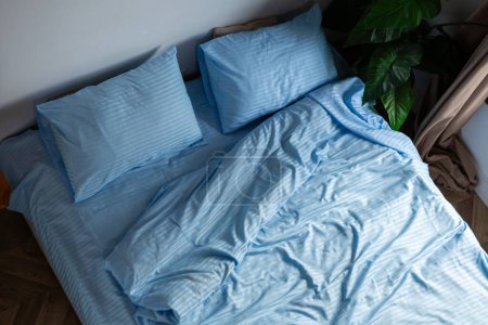 Téléchargez les photos : Une chambre minimale désordonnée avec un lit non fait - en image libre de droit