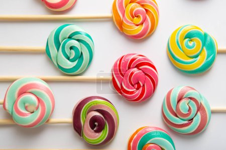 Photo for Spiral lolly pops candy on sticks on light surface - Royalty Free Image