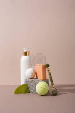 Téléchargez les photos : Bouteille cosmétique mousse de bain et gant de toilette, savon sur peau de surface beige et rouleau de soin du corps guasha - en image libre de droit