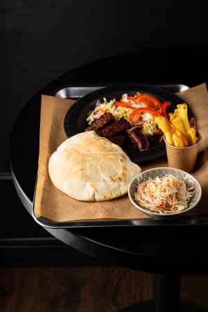 Vue aérienne du pain pita avec viande et salade sur table noire