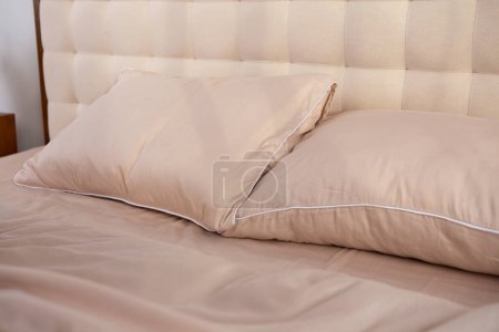 Foto de Ropa de cama de satén beige claro y almohadas - Imagen libre de derechos