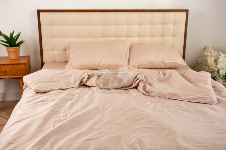 Téléchargez les photos : Linge de lit et oreillers beige clair en satin sur le lit - en image libre de droit