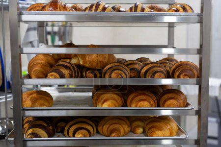 close up of freshly baked croissants cooling on the stand bakery