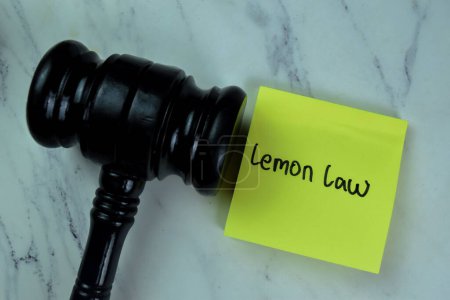 Foto de Concepto de Ley de Limón escribir en notas adhesivas con mazo aislado en la mesa de madera. - Imagen libre de derechos