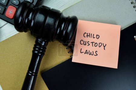 Photo for Concept of Child Custody Laws write on sticky notes with gavel isolated on Wooden Table. - Royalty Free Image