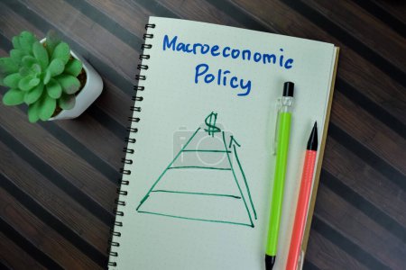 Foto de Concepto de política macroeconómica escribir sobre un libro aislado en la mesa de madera. - Imagen libre de derechos