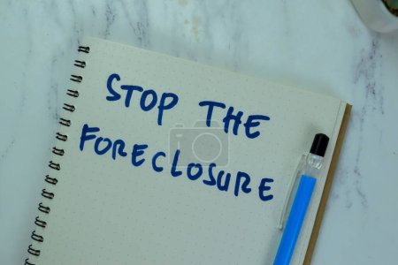 Photo for Concept of Stop The Foreclosure write on a book isolated on Wooden Table. - Royalty Free Image