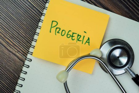 Foto de Concept of Progeria write on sticky notes with stethoscope isolated on Wooden Table. - Imagen libre de derechos