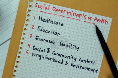 Foto de Concepto de Determinantes Sociales de la Salud escribir en libro de papel aislado en tabla de madera. - Imagen libre de derechos