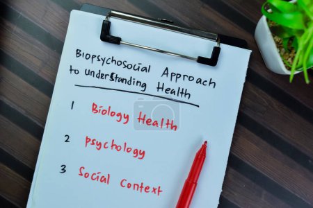Téléchargez les photos : Concept de l'approche biopsychosociale pour comprendre la santé écrire sur la paperasserie isolée sur la table en bois. - en image libre de droit