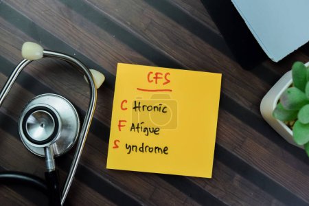 Konzept von CFS - Chronic Fatigue Syndrome schreiben auf klebrige Notizen mit Stethoskop isoliert auf Holztisch.