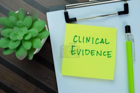 Photo for Concept of Clinical Evidence write on sticky notes isolated on Wooden Table. - Royalty Free Image