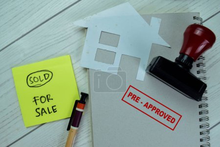Photo for Concept of Red Handle Rubber Stamper and Pre-Approved text with Sold For Sale on sticky notes isolated on on Wooden Table. - Royalty Free Image