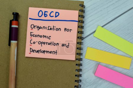 Konzept der OECD - Organisation für wirtschaftliche Zusammenarbeit und Entwicklung schreibt auf klebrige Zettel isoliert auf Holztisch.