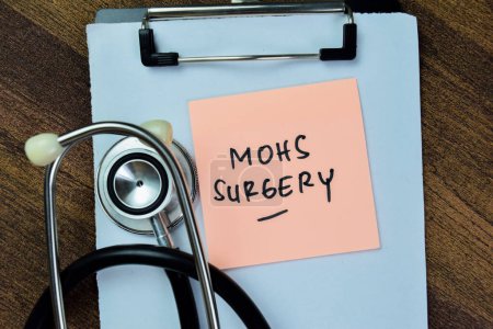 Konzept der MOHS-Chirurgie schreiben auf klebrigen Zetteln mit Stehoskop isoliert auf Holztisch.