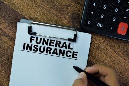 Concept of Funeral Insurance write on paperwork on a book isolated on Wooden Table.