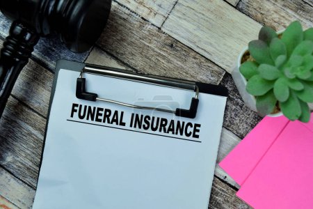 Concept of Funeral Insurance write on paperwork isolated on Wooden Table.