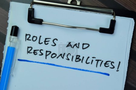Konzept der Rollen und Verantwortlichkeiten schreiben auf Papierkram isoliert auf Holztisch.