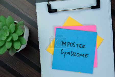Téléchargez les photos : Concept of Imposter Syndrome write on sticky notes isolated on Wooden Table. - en image libre de droit