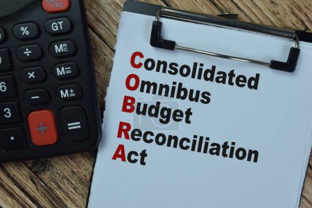 Concept of COBRA - Consolidated Omnibus Budget Reconciliation Act write on paperwork isolated on Wooden Table.
