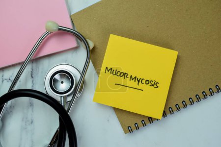 Photo for Concept of Mucormycosis write on sticky notes with stethoscope isolated on Wooden Table. - Royalty Free Image