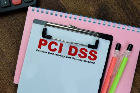 Concept of PCI DSS - Payment Card Industry Data Security Standard write on paperwork isolated on Wooden Table.