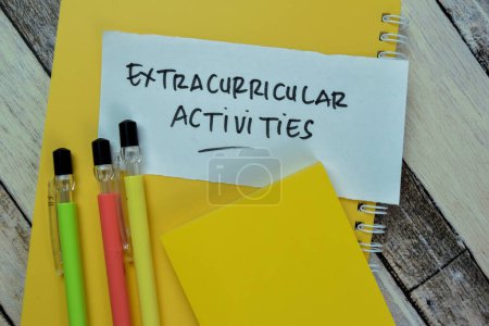 Foto de Concepto de actividades extracurriculares escribir en notas adhesivas aisladas en la mesa de madera. - Imagen libre de derechos