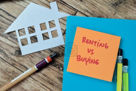 Concept of Renting Vs Buying write on sticky notes isolated on Wooden Table.