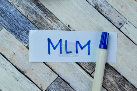 Photo for Concept of MLM write on sticky notes isolated on Wooden Table. - Royalty Free Image