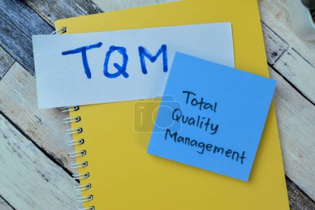 Photo for Concept of TQM - Total Quality Management write on sticky notes isolated on Wooden Table. - Royalty Free Image