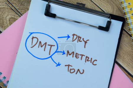 Foto de Concepto de DMT - Dry Metric Ton escribir en el papeleo aislado en la mesa de madera. - Imagen libre de derechos