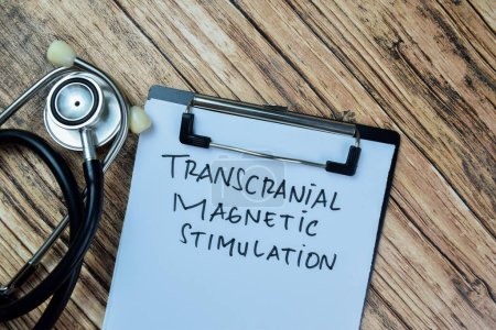 Concept of Transcranial Magnetic Stimulation write on paperwork isolated on Wooden Table.