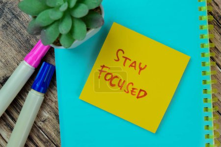 Photo for Concept of Stay Focused write on sticky notes isolated on Wooden Table. - Royalty Free Image